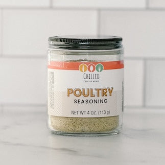 Jar of poultry seasoning on a white surface with a tiled wall background