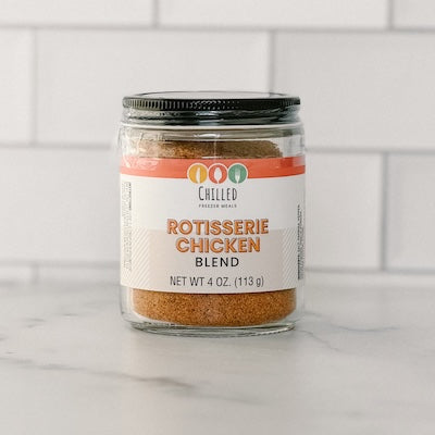 jar of rotisserie chicken blend seasoning on a white surface with tile background